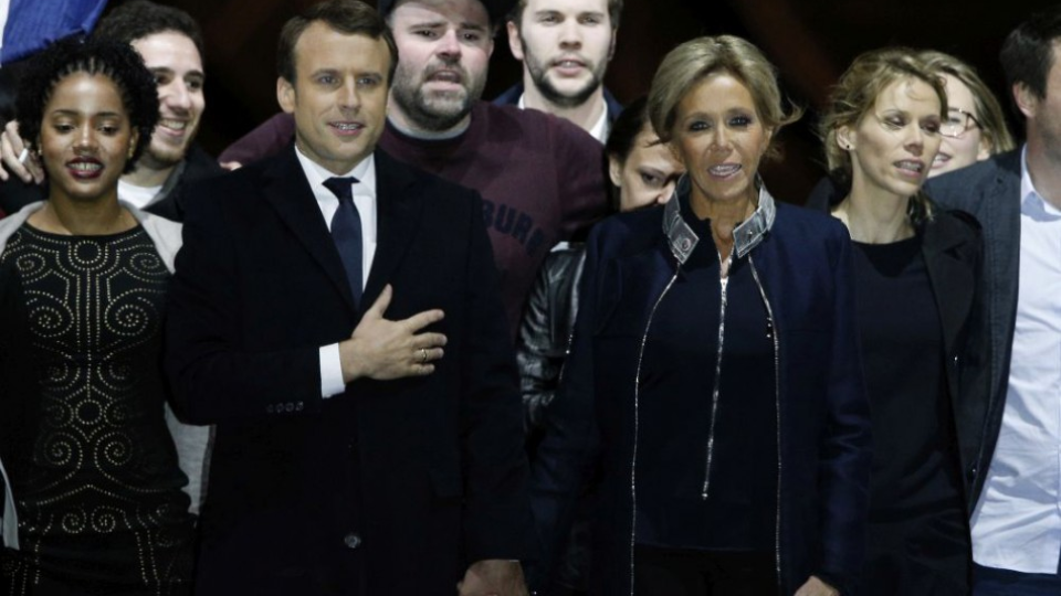 Emmanuel Macron s manželkou Brigitte sa držia za ruky a spievajú francúzsku hymnu Marseillaise počas oslavy víťazstva vo voľbách,7.mája 2017.