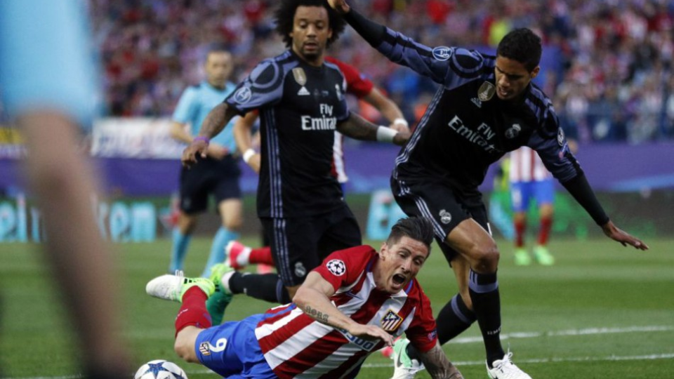 Pád Fernanda Torresa (Atletico Madrid) v súboji s Raphaelom Varanem (Real Madrid, vpravo) v druhom semifinálovom zápase Ligy majstrov. 10. mája 2017. 