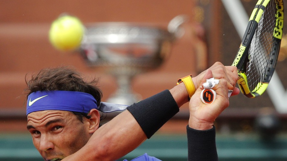Trofej pre víťaza vidno za Španielom  Rafaelom Nadalom, ktorý vracia loptičku Švajčiarovi Stanovi Wawrinkovi vo finálovom zápase mužskej dvojhry na turnaji French Open na dvorcoch Roland Garros v Paríži 11. júna 2017.