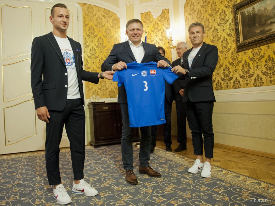 Predseda vlády SR Robert Fico (vľavo) prijal hráčov a členov realizačného tímu slovenskej futbalovej reprezentácie do 21 rokov. Na snímke vľavo kapitán Adam Zreľák a vpravo tréner Pavel Hapal odovzdávajú dres premiérovi 27. júna 2017 v Bratislave.