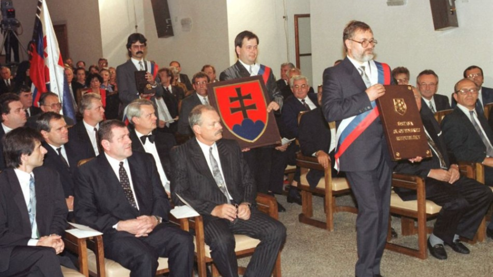Na archívnej snímke sprava poslanci Jozef Prokeš Vladimír Bajan a Milan Ftáčnik prinášajú Ústavu, štátny znak, pečať a vlajku SR v Rytierskej sieni na Bratislavskom hrade  3. septembra 1992.