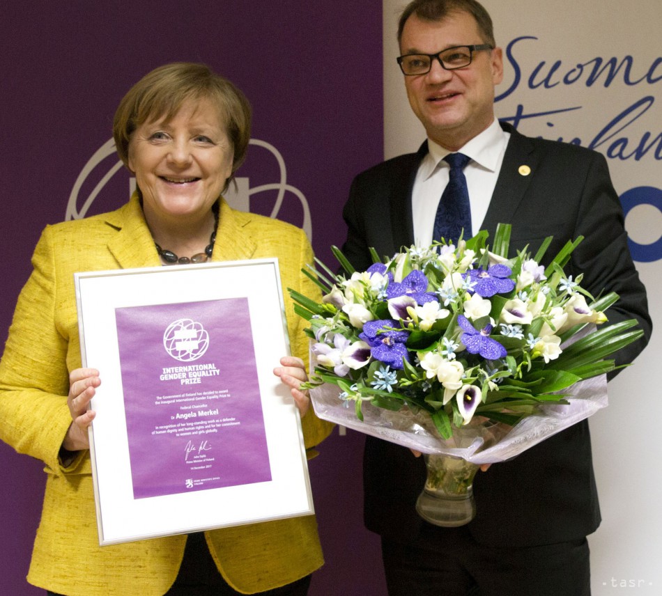 Nemecká kancelárka Angela Merkelová (vľavo) pózuje s Medzinárodnou cenou rodovej rovnosti, ktorú jej odovzdal fínsky premiér Juha Sipilä na summite EÚ v Bruseli 14. decembra 2017. Merkelová sa stala úvodnou laureátkou Medzinárodnej ceny rodovej rovnosti. Fínska vláda vytvorila toto ocenenie pri príležitosti osláv stého výročia vyhlásenia nezávislosti krajiny s cieľom podporiť rodovú rovnosť. 