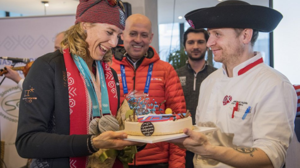 Na snímke zľava slovenská biatlonistka Anastasia Kuzminová si preberá tortu, uprostred prezident SOV Anton Siekel v Slovenskom dome počas XXIII. zimných olympijských hier v juhokórejskom Pjongčangu 18. februára 2018.