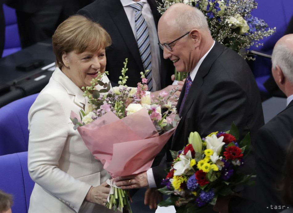 Nemecká kancelárka Angela Merkelová prijíma kyticu kvetov od Volkera Kaudera z CDU po jej opätovnom zvolení za spolkovú kancelárku.