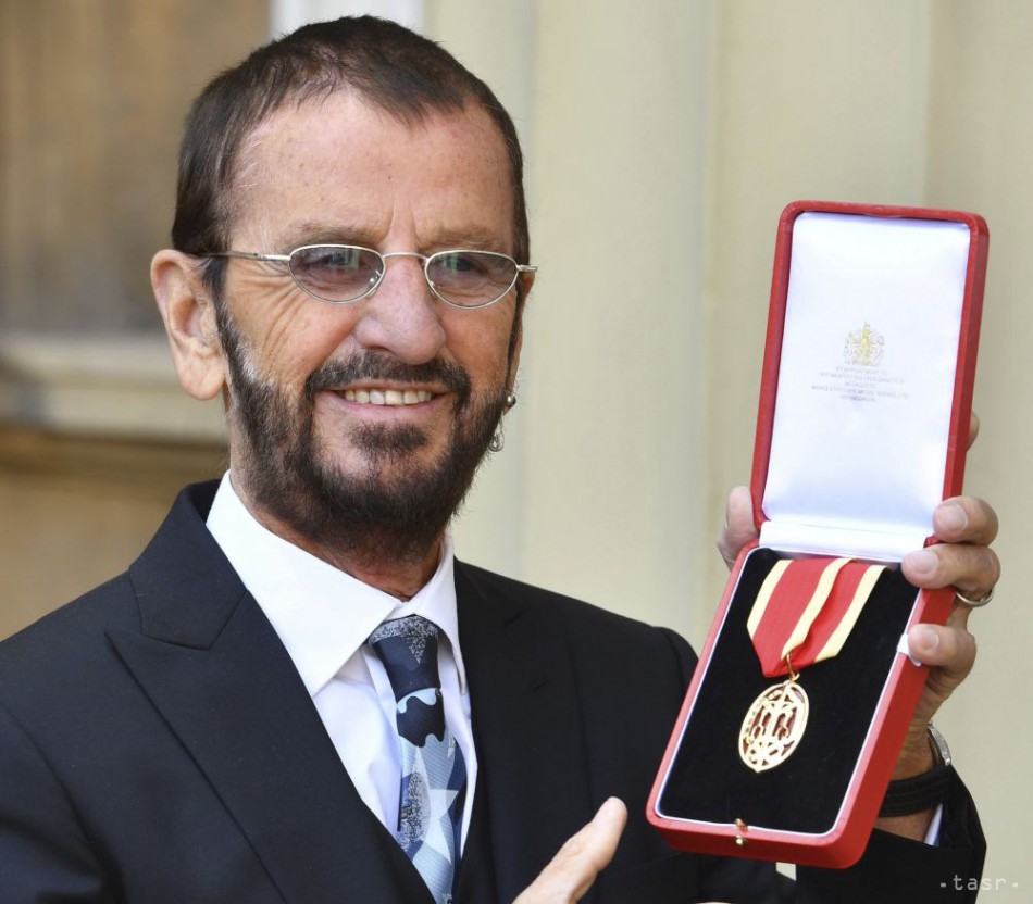 Bývalý člen skupiny The Beatles Ringo Starr ukazuje medailu čestného rytiera, ktorú mu udelil britský princ William v Buckinghamskom paláci v Londýne, 20. marca 2018.