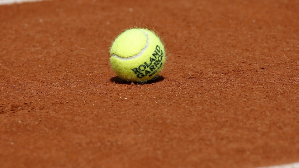 Tenisová loptička na kurte štadióna  Roland Garros v Paríži 25. mája 2018. Grandslamový tenisový turnaj French Open sa začína v nedeľu 27. mája.