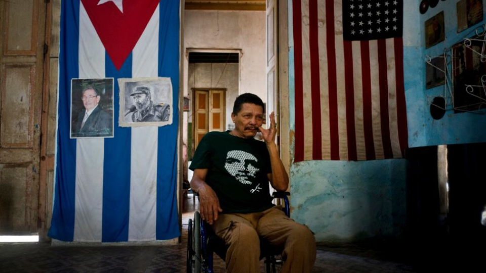 Na snímke muž a za ním fotografie Fidela a Raula Castra, v Havane na Kube.