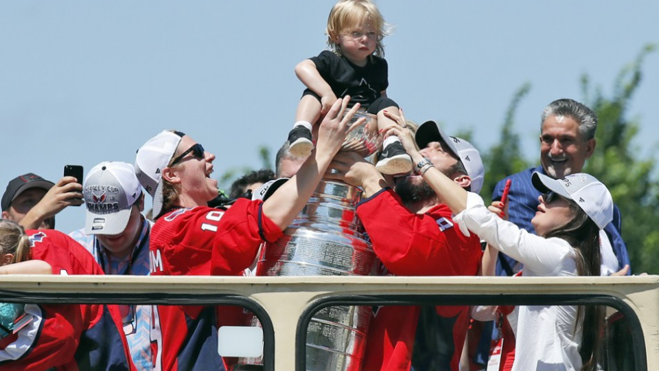Center Washingtonu Capitals Nicklas Bäckström (vľavo) drží svojho syna v Stanleyho pohári počas osláv 12. júna 2018 vo Washingtone. 