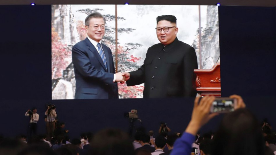 Juhokórejský prezident Mun Če-in a severokórejský vodca Kim Čong-un si podávajú ruky počas summitu.