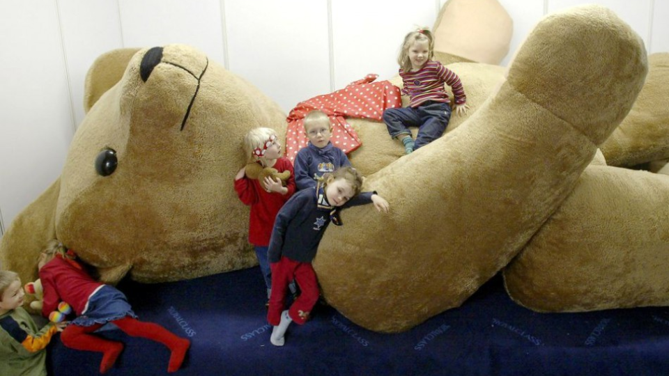 Škôlkári pózujú pri obrovskom plyšovom medvedíkovi na Teddy Show v nemeckom Lipsku 23.októbra 2002. - archívne foto