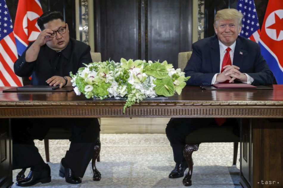Americký prezident Donald Trump (vpravo) a severokórejský líder Kim Čong-un pózujú po podpise komplexnej dohody, ktorej obsah nebol zverejnený počas historického stretnutia v Singapure.