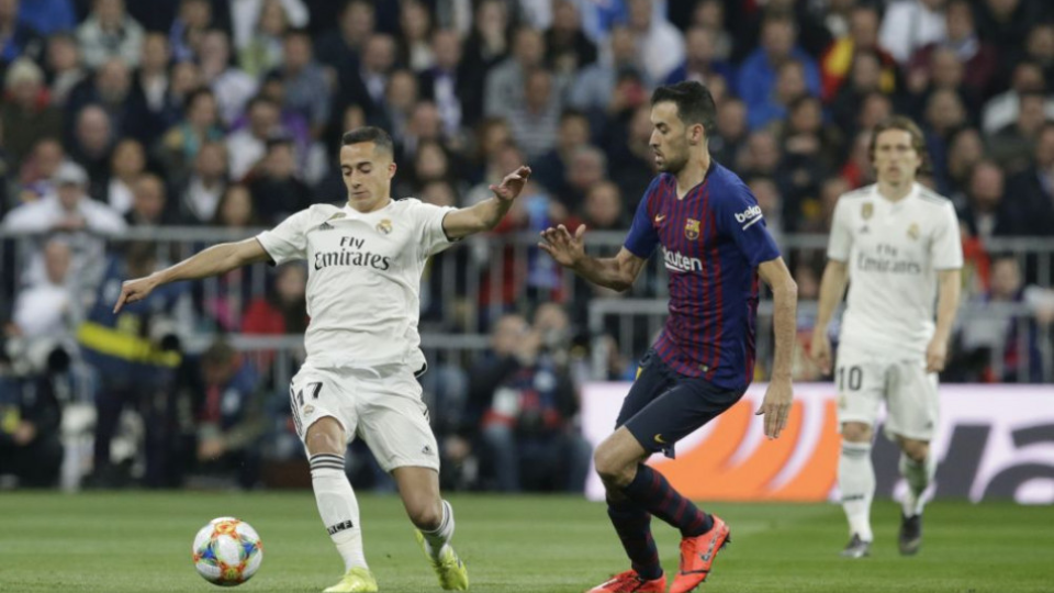 Na snímke sprava hráč Barcelony Sergio Busquets  a hráč Realu Lucas  Vazquez v odvete semifinále Kráľovského pohára vo futbale Real Madrid - FC Barcelona v Madride 27. februára 2019.