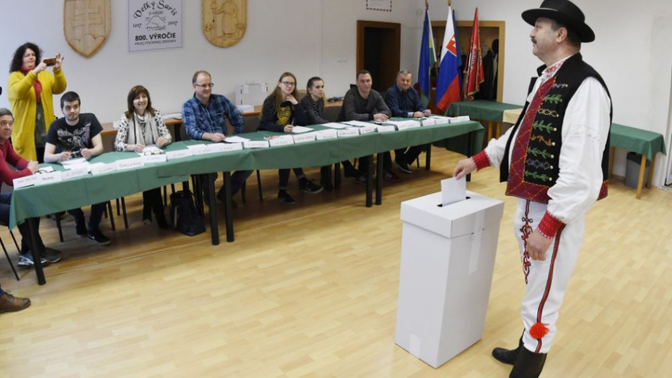 Na snímke člen miestneho FS Šarišske gavalire odetý v kroji vhadzuje hlasovací lístok do volebnej urny počas 1. kola prezidentských volieb v meste Veľký Šariš, okres Prešov v sobotu 16. marca 2019.