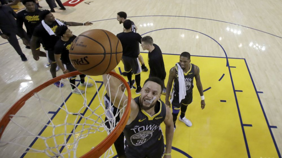 Na snímke vpravo hráč Warriors Stephen Curry hádže loptu do koša, vľavo jeho spoluhráči oslavujú víťazstvo v 2. zápase 3. kola play off Západnej konferencie basketbalovej NBA  Golden State Warriors - Portland Trail Blazers (114:111) v noci na 17. mája 2019. 