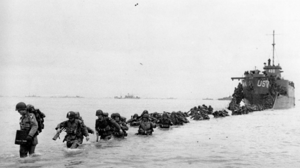 Na archívnej snímke z júna 1944 americké vojenské posily sa brodia vodou cestou z lode na pobrežie niekoľko dní po tzv. 