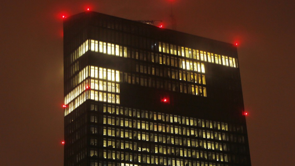Rozsvietená budova Európskej centrálnej banky vo Frankfurte nad Mohanom. 