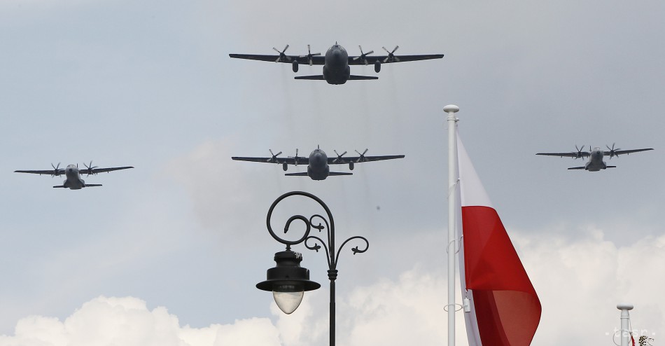 Archívne foto: Lietadlá poľskej armády C-130 Hercules letia ponad poľskú vlajku počas vojenskej prehliadky vo Varšave. 