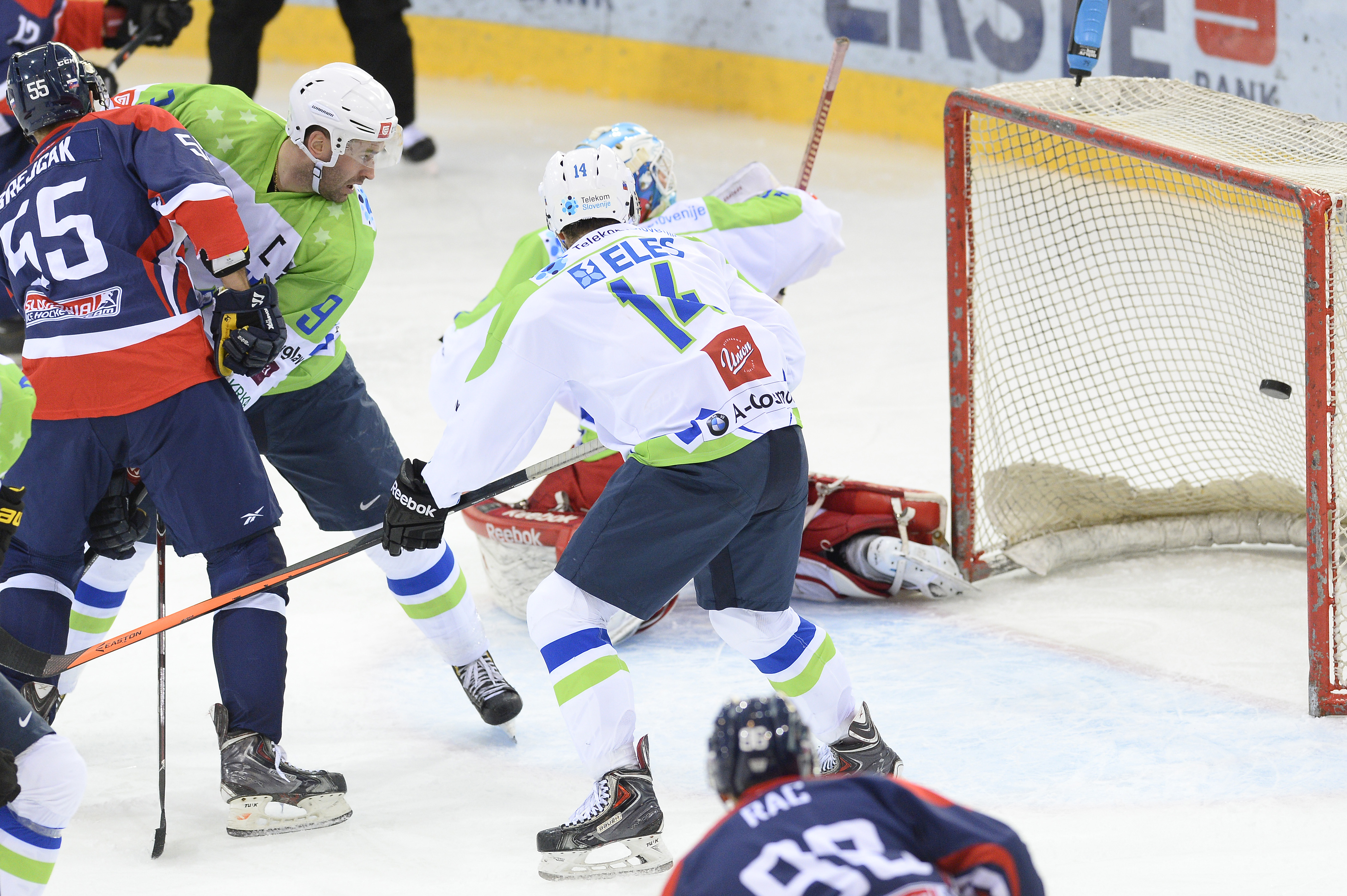 Vľavo Ján Brejčák (Olympijský tím SR) a v strede Matic Podlipnik  (Slovinsko) sa prizerajú gólu v zápase turnaja Euro Ice Hockey Challenge Slovinsko - Slovensko v rakúskej Viedni 6. februára 2015.