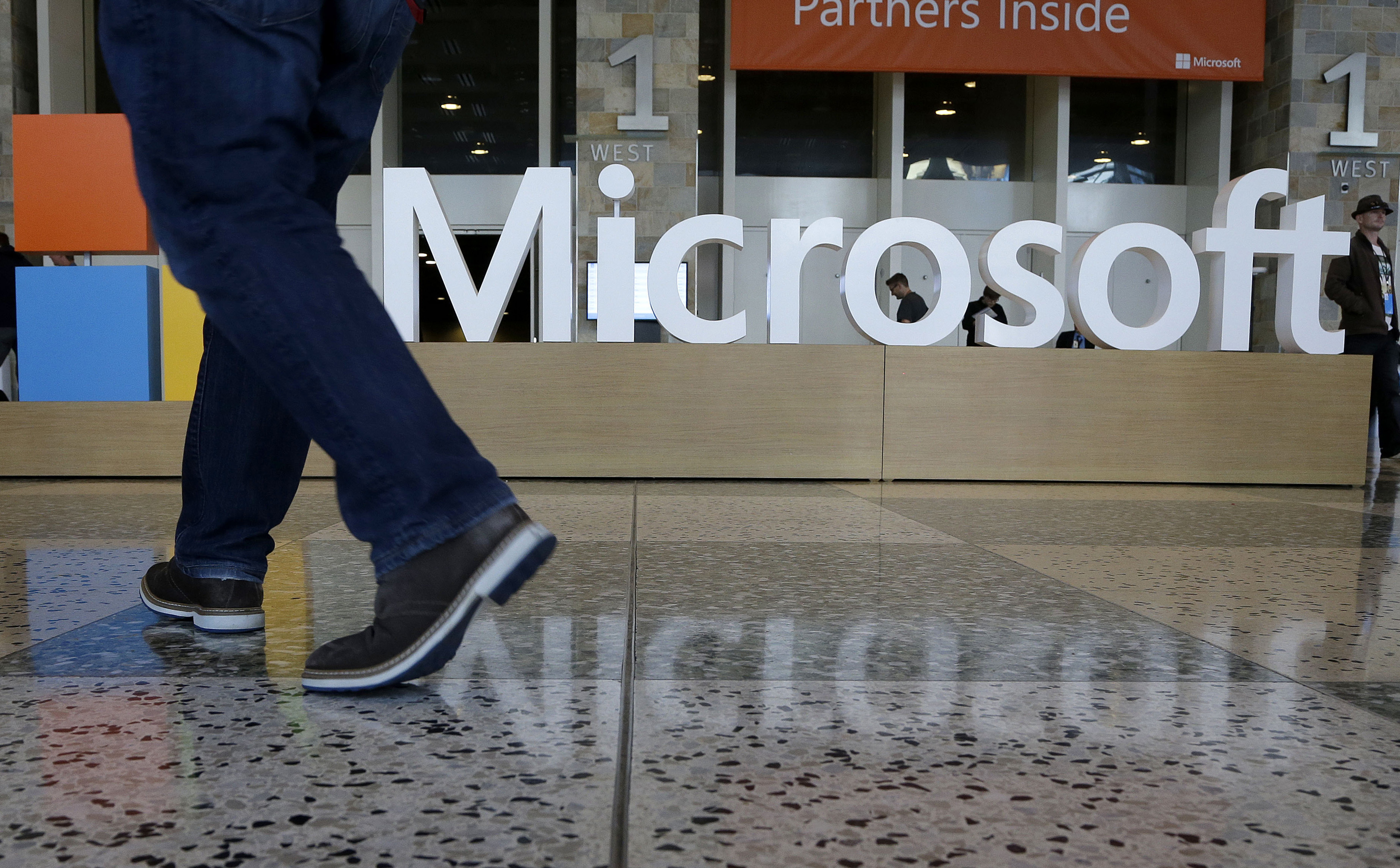 Na archívnej snímke muž prechádza okolo loga americkej softvérovej spoločnosti Microsoft v San Franciscu.