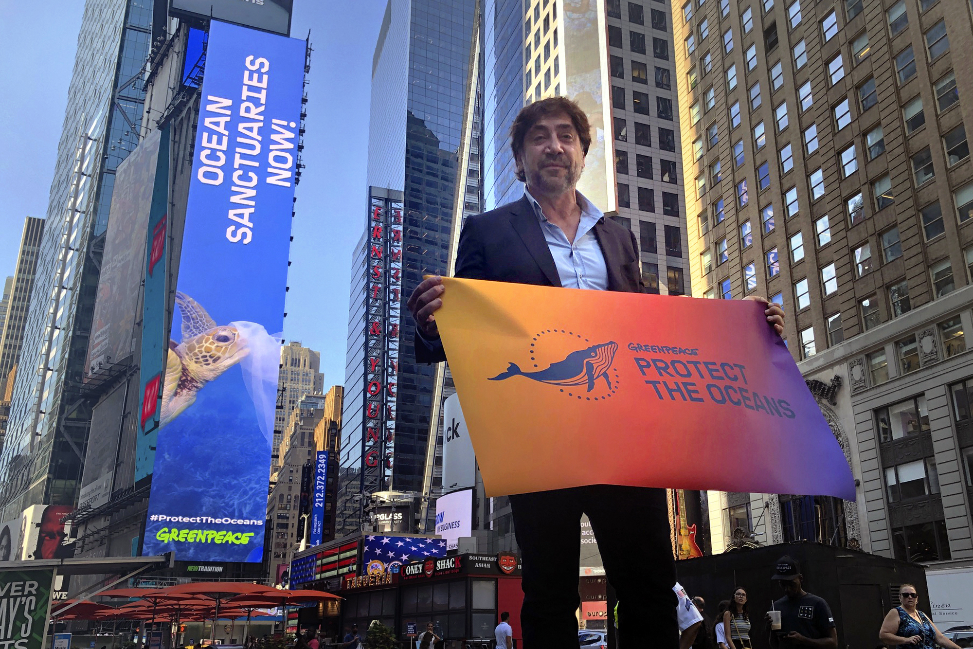 Španielsky oscarový herec Javier Bardem  pózuje s transparentom s nápisom Zachráňme svetové oceány na Times Square v New Yorku v pondelok 19. augusta 2019