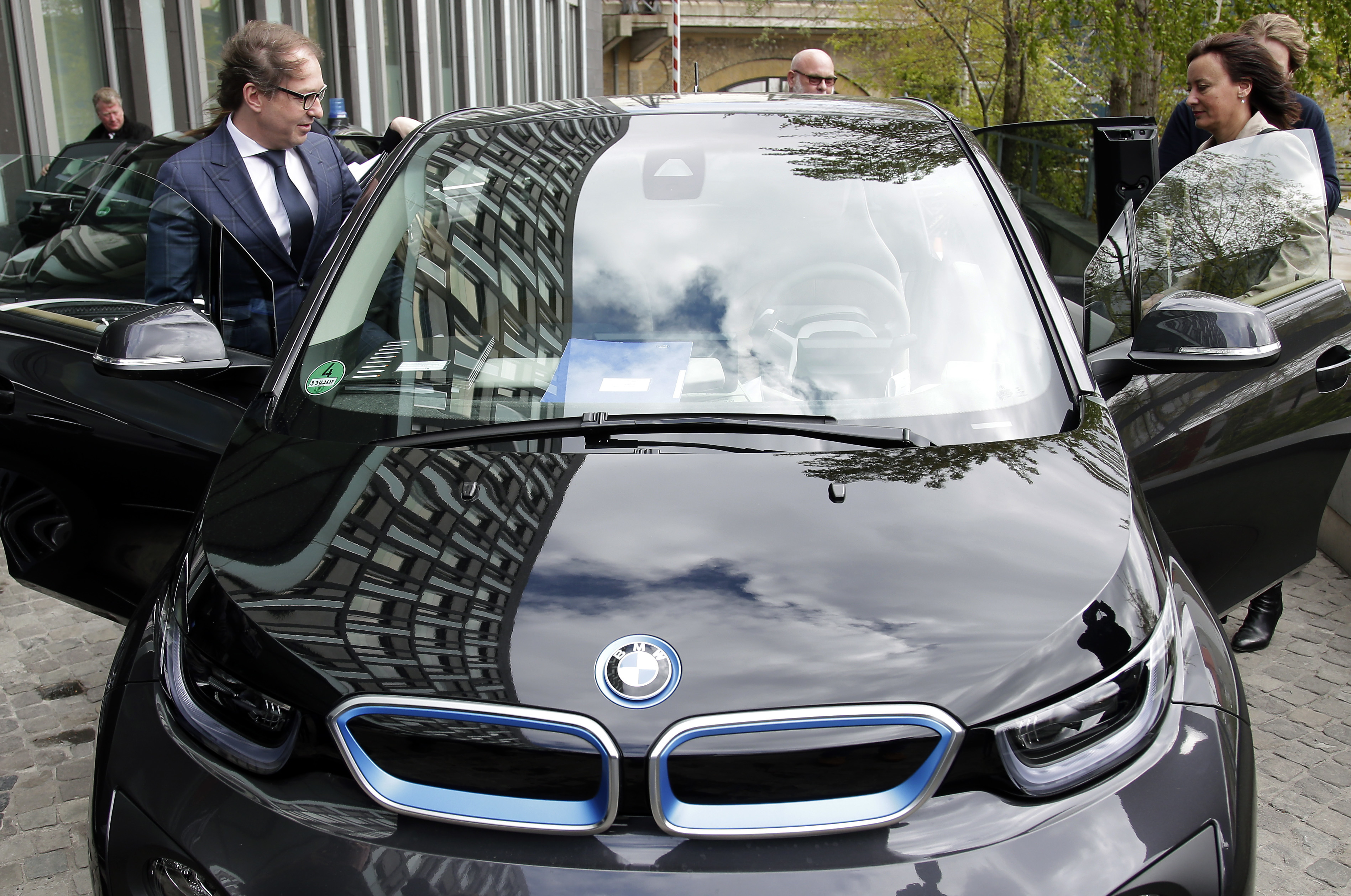Ilustračné foto - Nemecký  minister dopravy Alexander Dobrindt (vľavo) nastupuje do svojho ministerského elektromobilu.