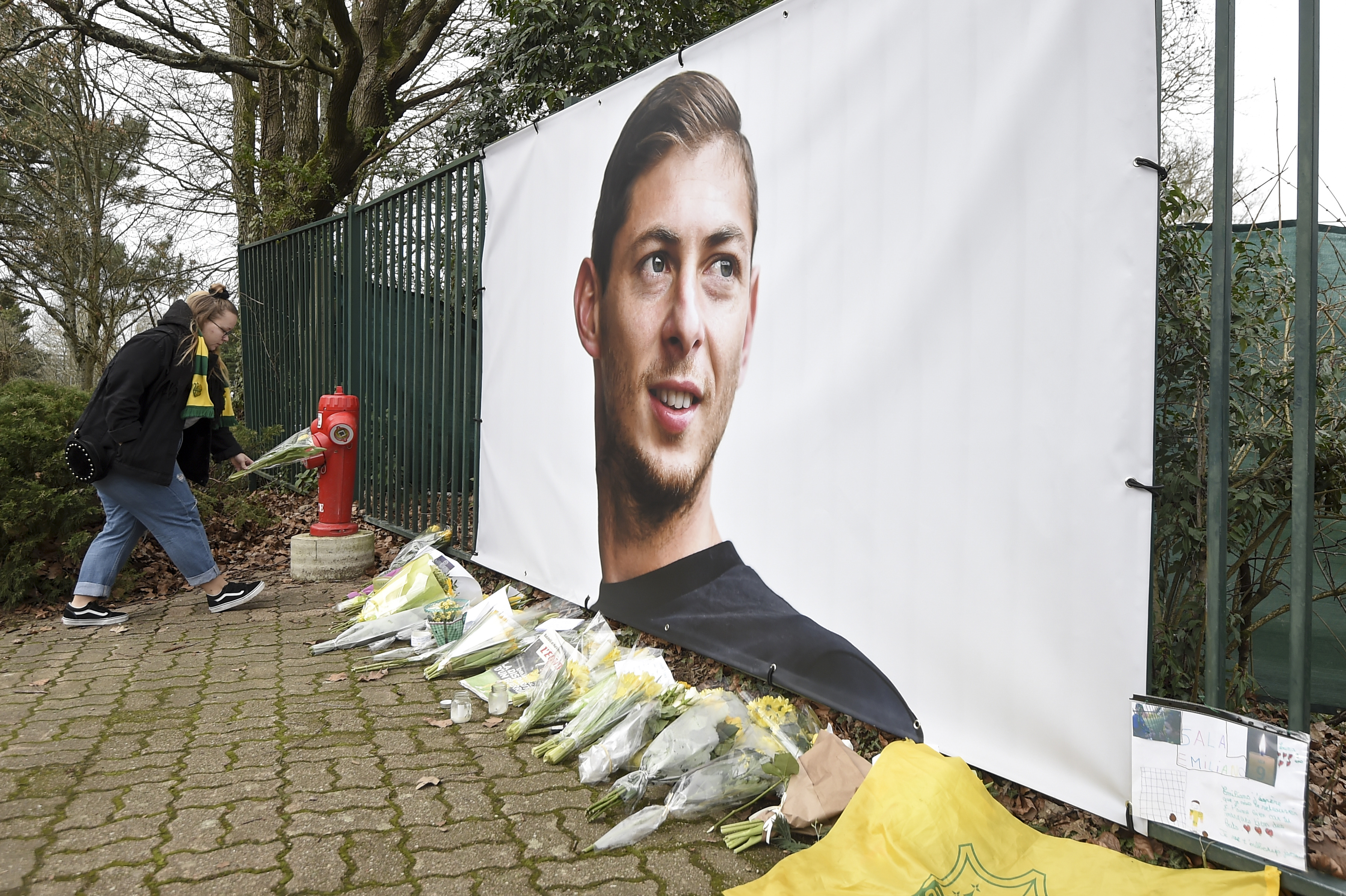 Kvety sú položené pred obrovským plagátom argentínskeho futbalistu Emiliana Salu  pred tréningovým kempom FC Nantes
