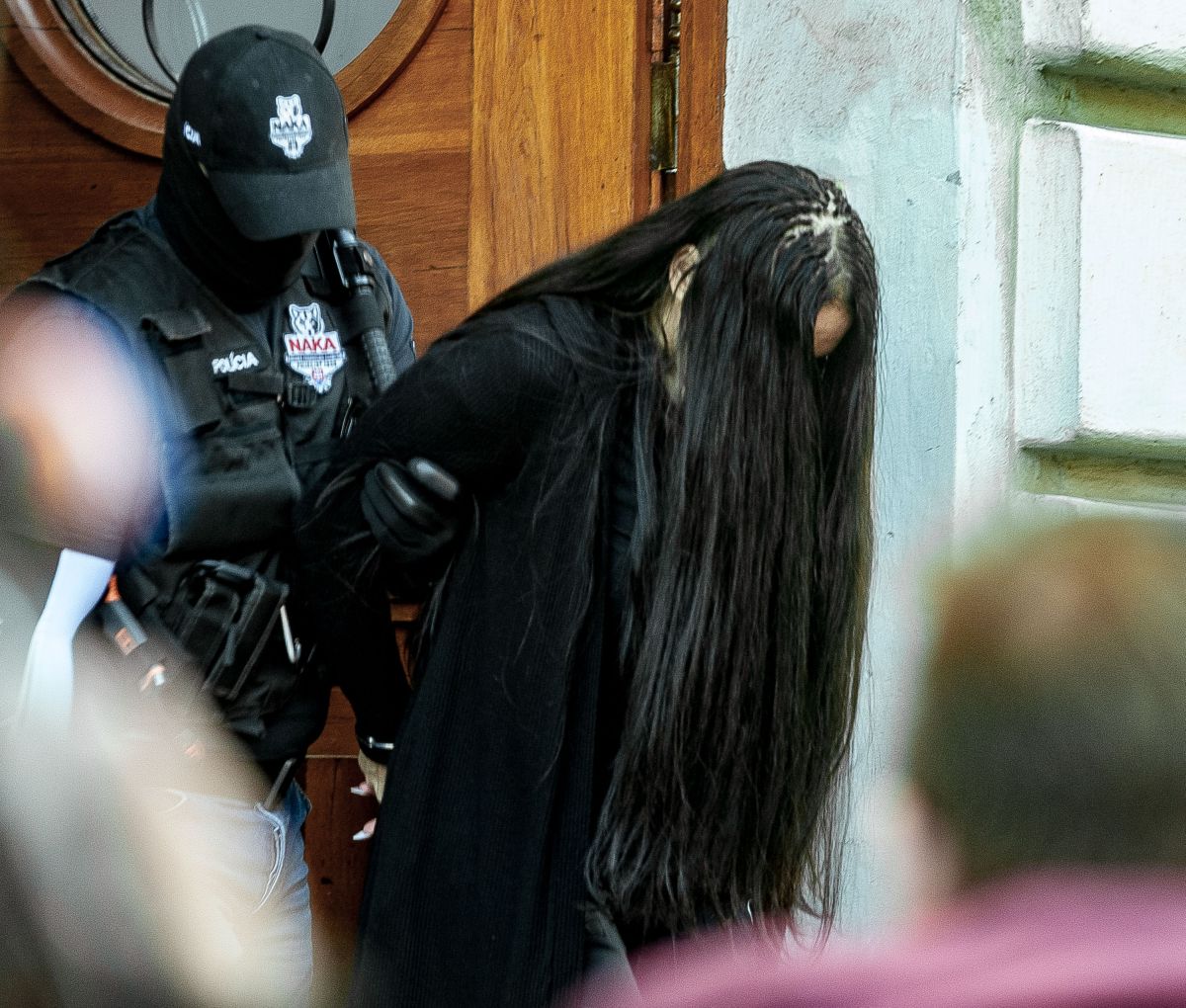 Na snímke polícia odvádza Alenu Zsuzsovú