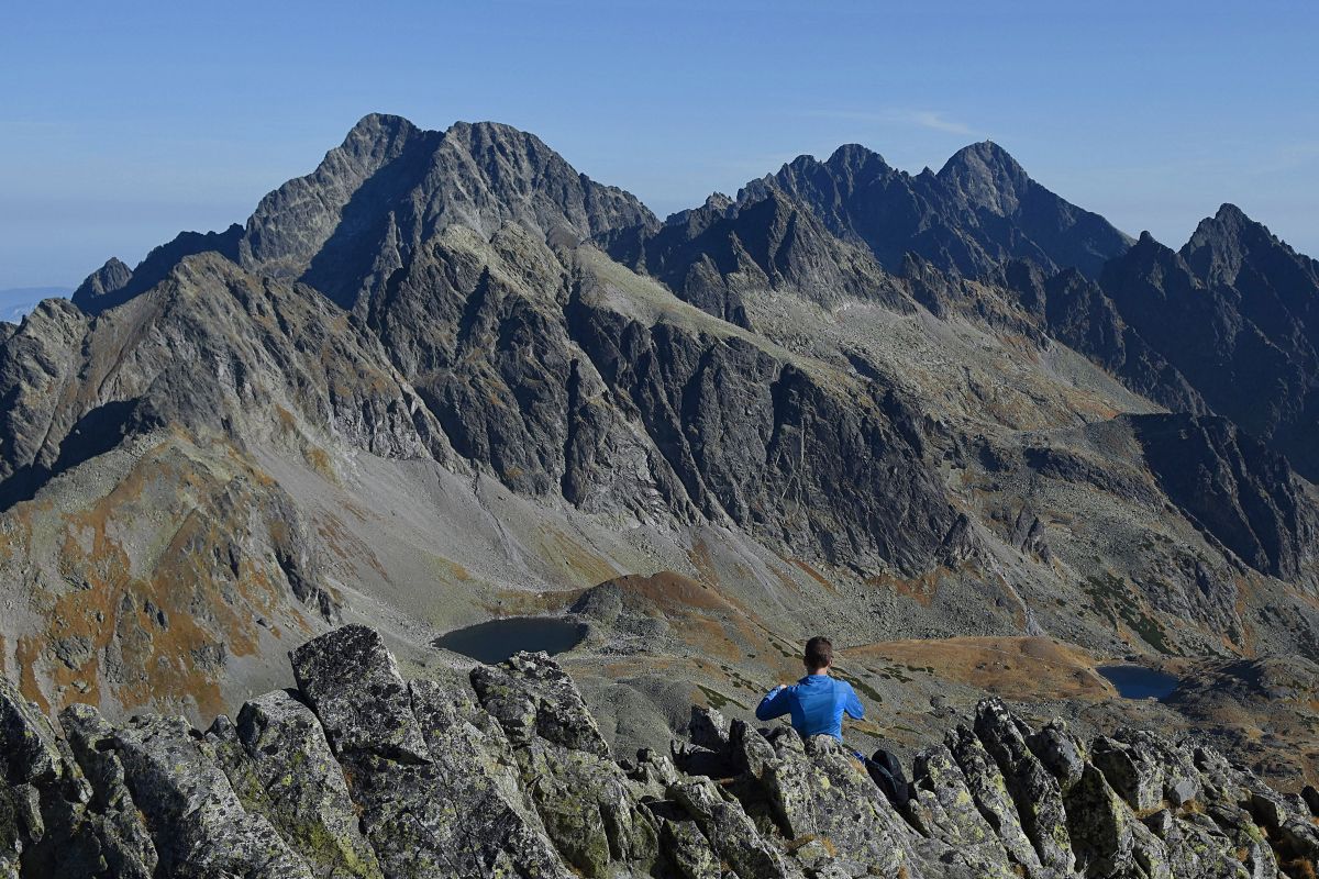Na snímke sa turista kochá výhľadom na Veľkú studenú dolinu a okolité štíty z vrcholu Východnej Vysokej vo Vysokých Tatrách