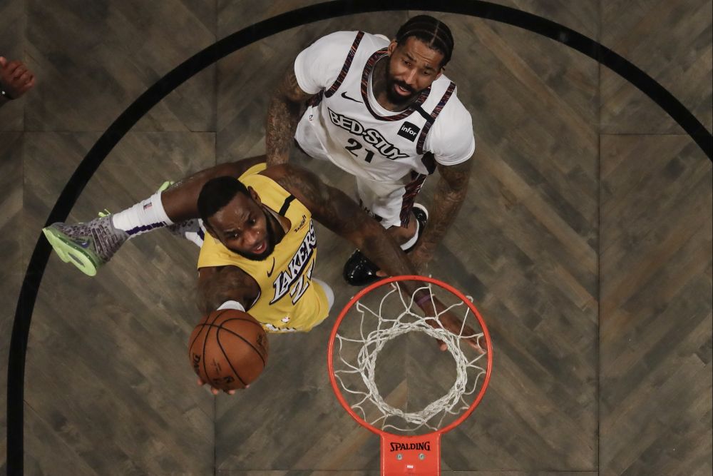 Hráč Los Angeles Lakers LeBron James (vľavo) strieľa na kôš cez Wilsona Chandlera z Brooklynu Nets