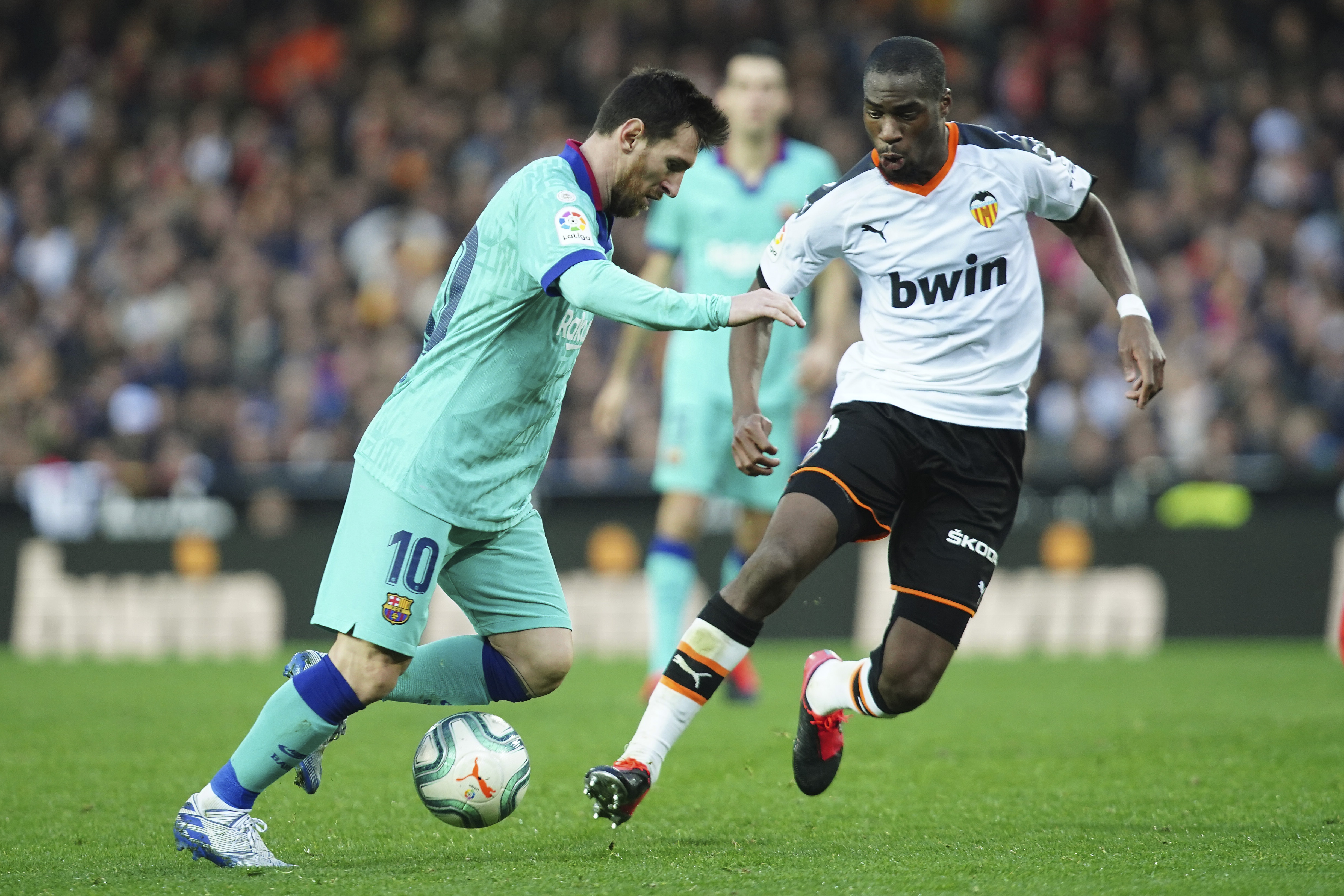 V zápase o loptu Lionel Messi (Barcelona) a Geoffrey Kondogbia (Valencia)