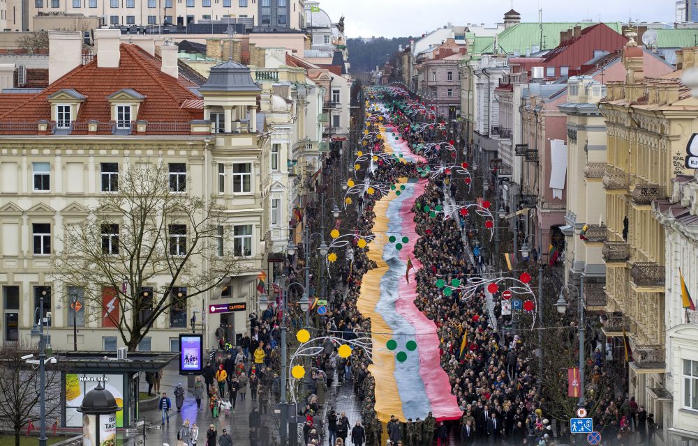 Ľudia nesú obrovskú litovskú zástavu počas osláv 30. výročia vyhlásenia nezávislosti od Sovietskeho zväzu