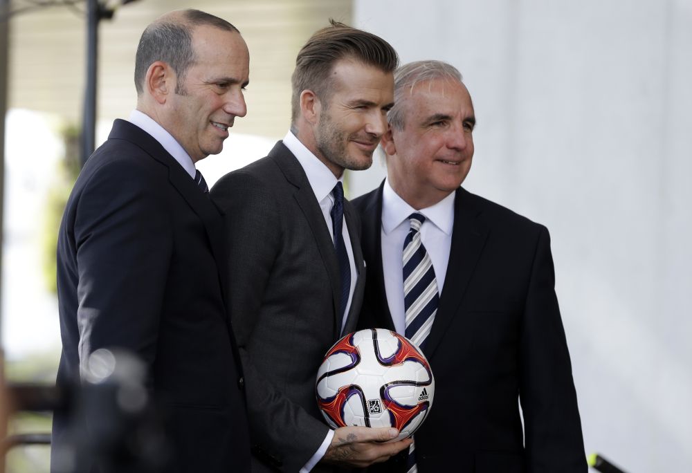 Bývalý anglický futbalista David Beckham (uprostred) , vľavo komisár MLS Don Garber a vpravo starosta Miami-Dade County Carlos Gimenez.