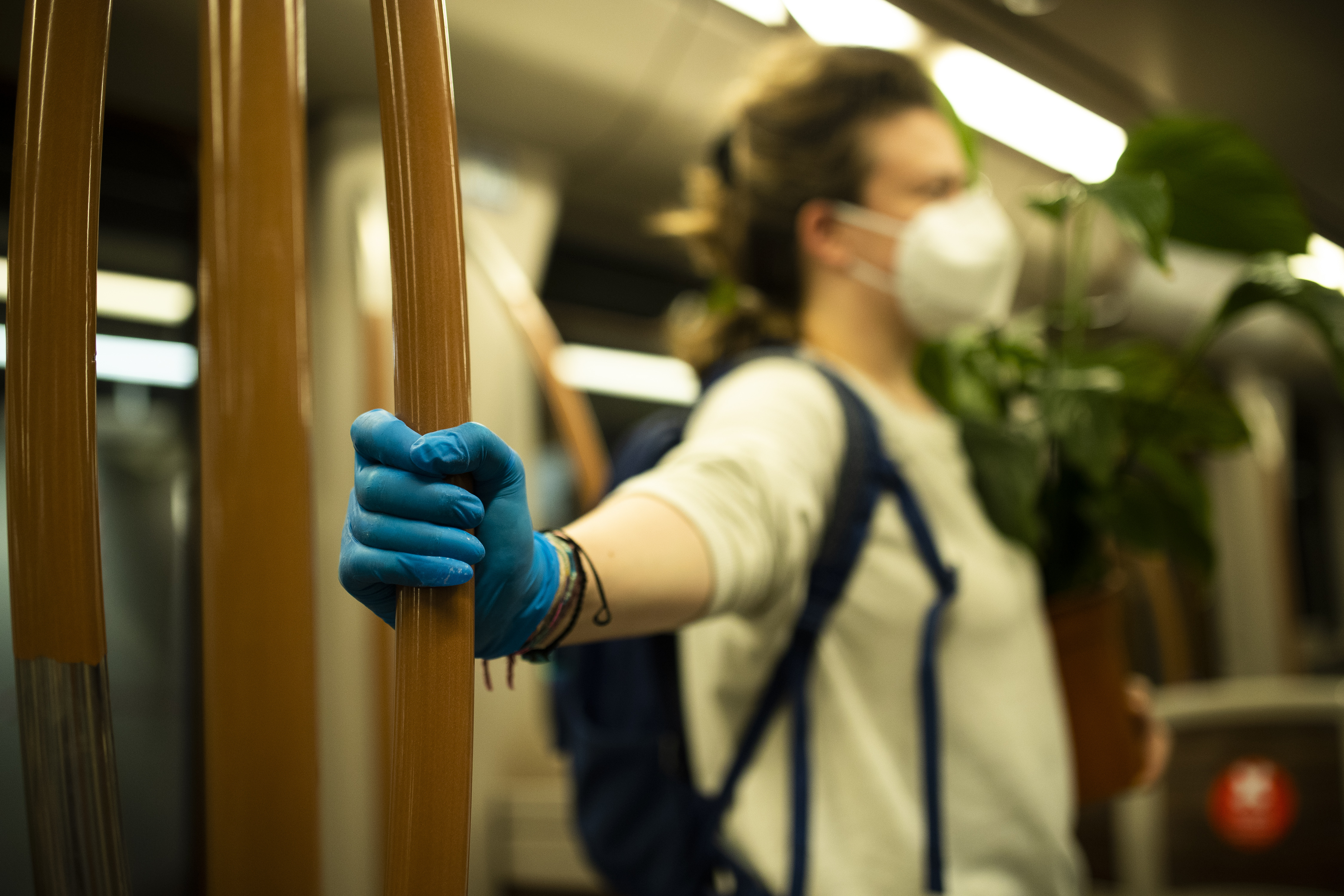 Žena s ochrannou maskou na tvári a rukavicami na zabránenie šírenia epidémie COVID-19 cestuje v takmer prázdnom metre v Bruseli 28. apríla 2020.
