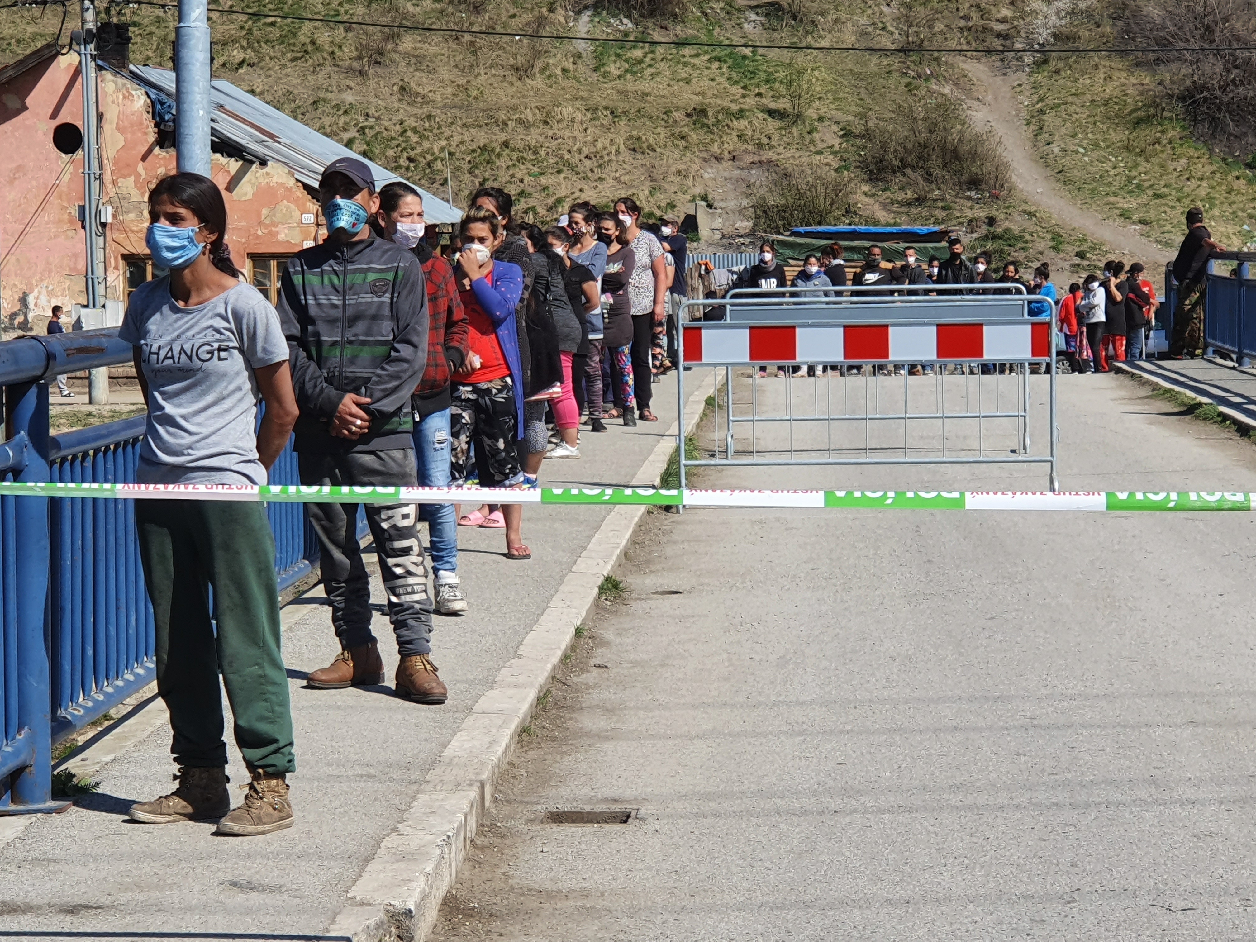 Na snímke ľudia čakajú v rade na sociálne dávky pred mobilným poštovým miestom v rómskej lokalite na Hornádskej ulici v Krompachoch, ktorá bolaa uzavretá pre výskyt nového typu koronavírusu. Krompachy, 17. apríla 2020.
