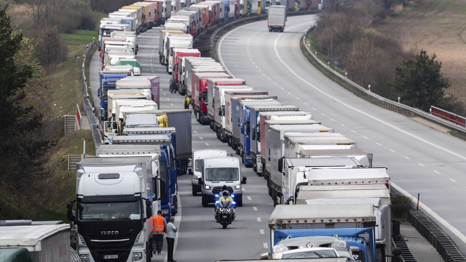 Nemeckí policajti jazdia na motorke medzi kamiónmi počas kolóny na diaľnici A4 neďaleko nemeckého Görlitzu 19. marca 2020. Obmedzenia zavedené na hraniciach s cieľom spomaliť šírenie koronavírusu v Európe spôsobili zdržania a kolóny na viacerých miestach v strednej Európe.
