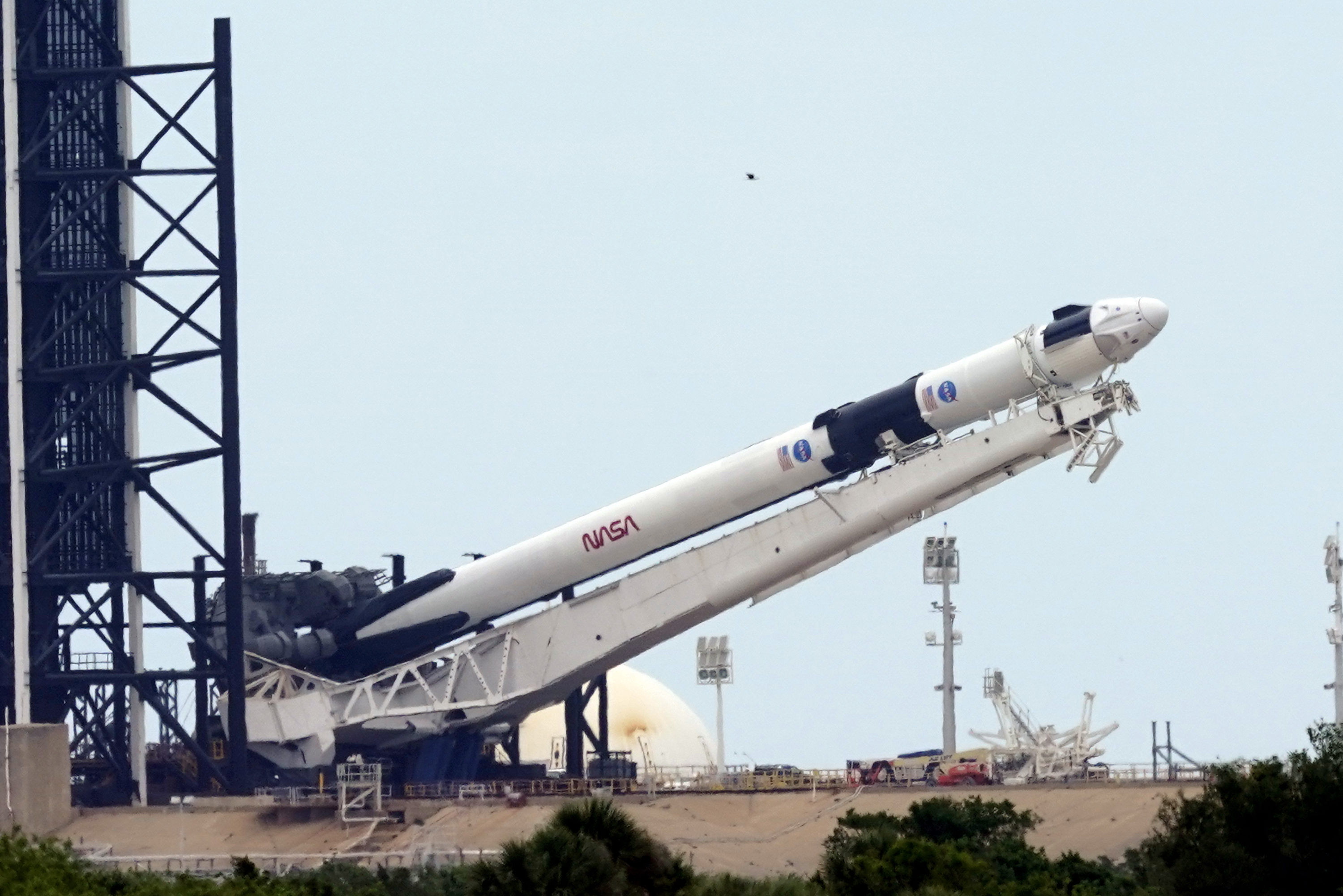 Raketa SpaceX Falcon 9  s vesmírnou loďou Crew Dragon pred štartom z Kennedyho vesmírneho strediska na Myse Kanaveral na Floride 26. mája 2020. Raketa na Medzinárodnú vesmírnu stanicu (ISS) po prvý raz povezie aj ľudskú posádku.