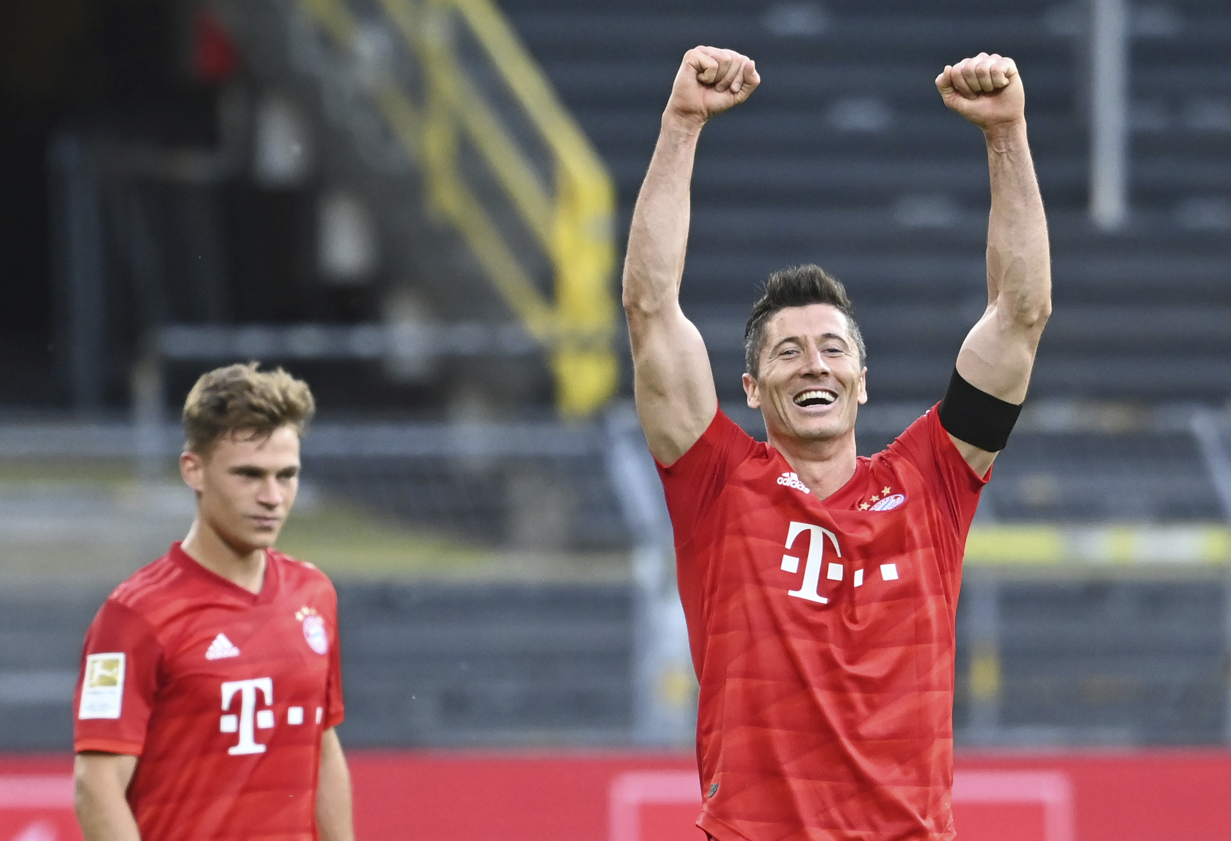 Futbalisti Bayernu Mníchov zľava Joshua Kimmich  a Robert Lewandowski sa tešia po výhre 1:0 v zápase 28. kola nemeckej futbalovej Bundesligy Borussia Dortmund - Bayern Mníchov