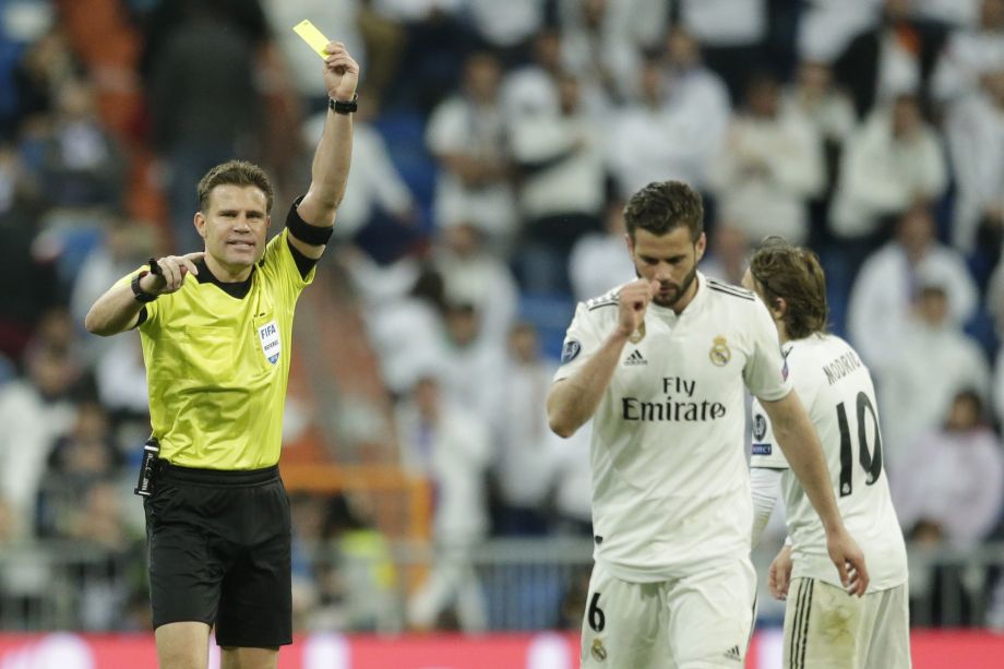 Rozhodca Felix Brych ukazuje žltú kartu obrancovi Realu Madrid Nachovi Fernandezovi