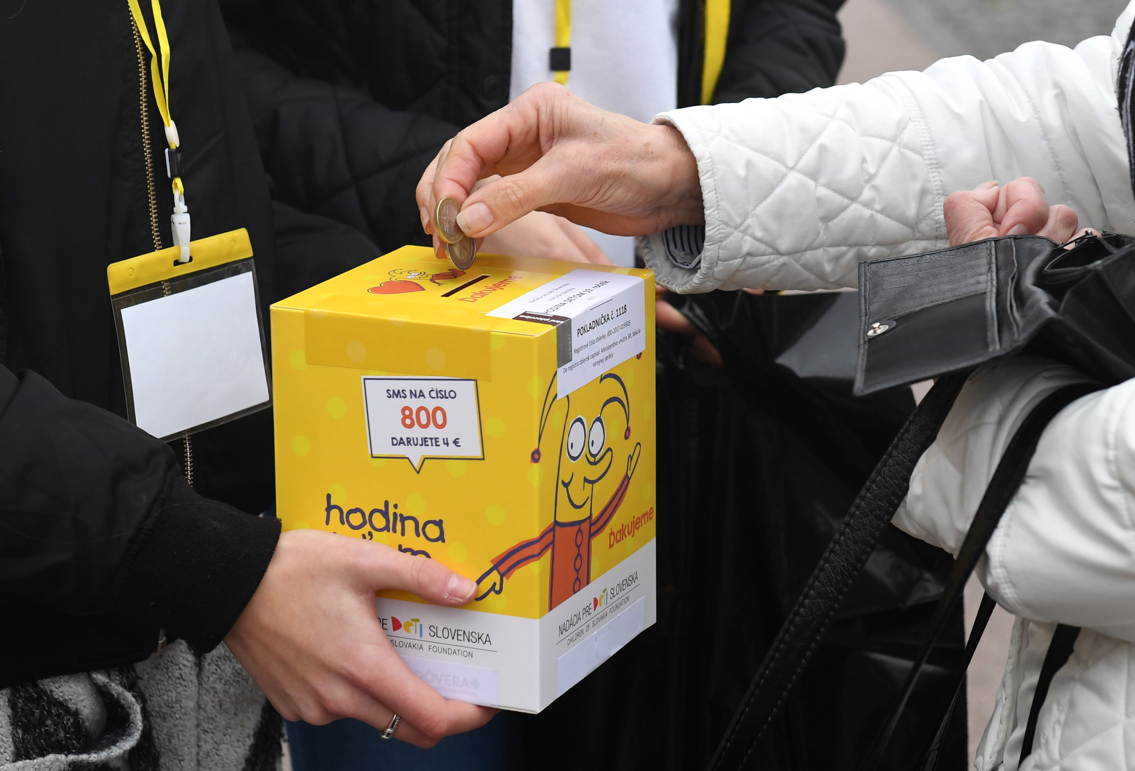 Na snímke darca hádže mince do žltej pokladničky počas zbierky Hodina deťom v roku 2017.