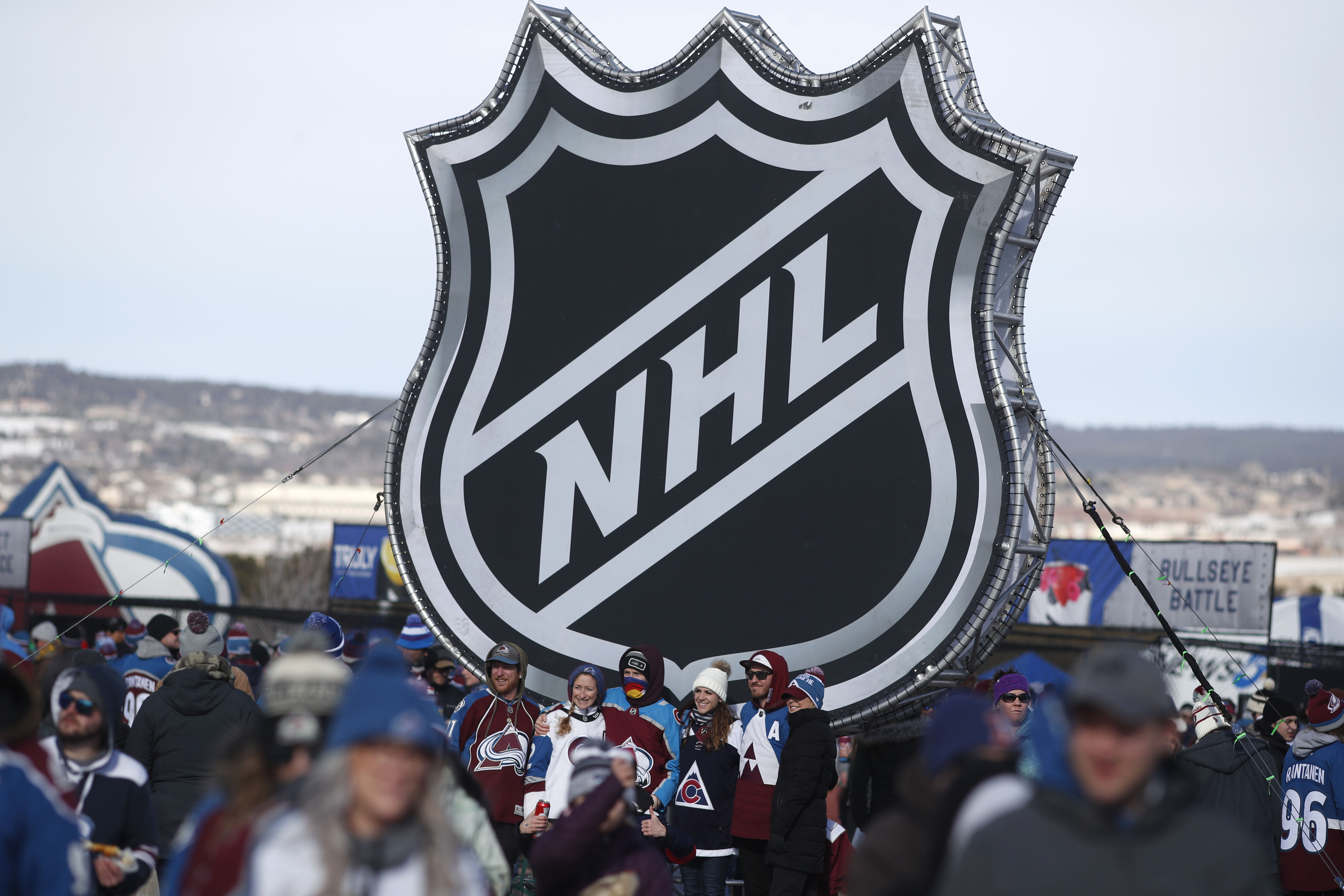 Na archívnej snímke z 15. februára 2020 fanúšikovia pózujú s logom NHL pred začiatkom zápasu pod holým nebom medzi Los Angeles Kings - Colorado Avalanche.