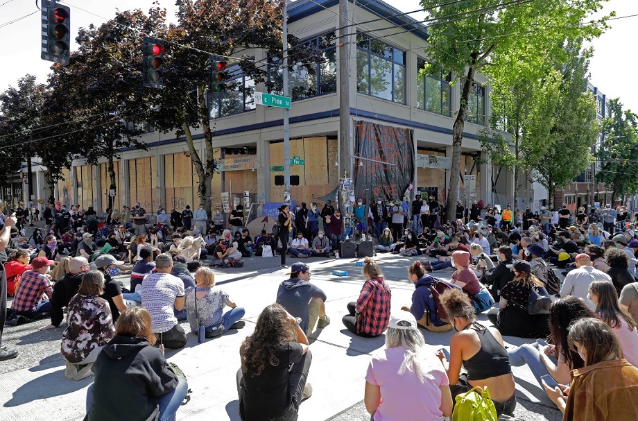Demonštranti sedia pred sídlom miestneho policajného oddelenia počas protestu proti policajnej brutalite v Seattle, archívna snímka.