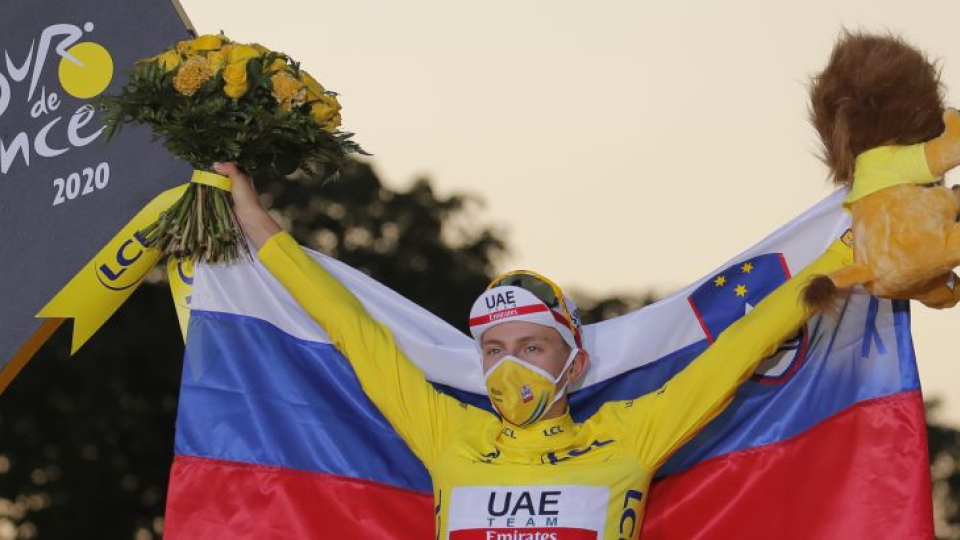Na snímke mladý slovinský pretekár Tadej Pogačar oslavuje na pódiu v žltom drese