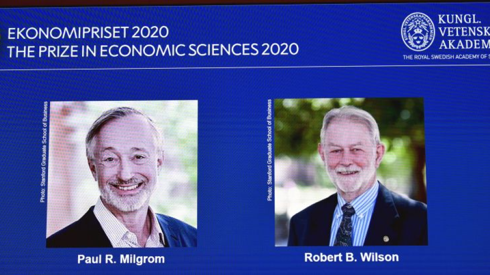 Laureáti Nobelovej ceny za ekonómiu sú zobrazení na monitore Američania zľava Paul Milgrom a Robert Wilson