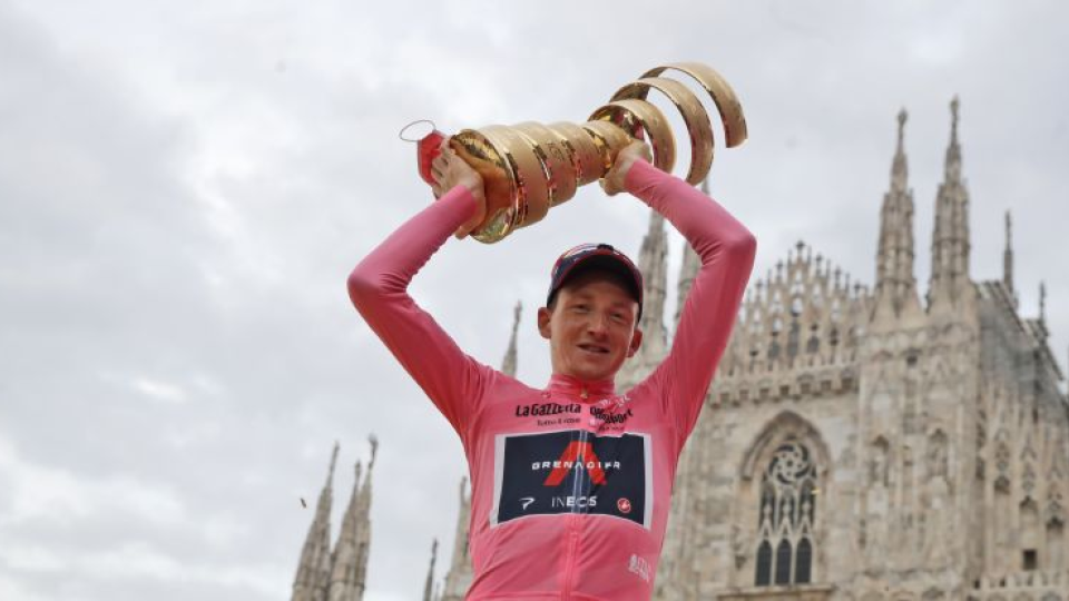 Britský cyklista Tao Geoghegan Hart z tímu Ineos Grenadiers pózuje v ružovom drese a s trofejou