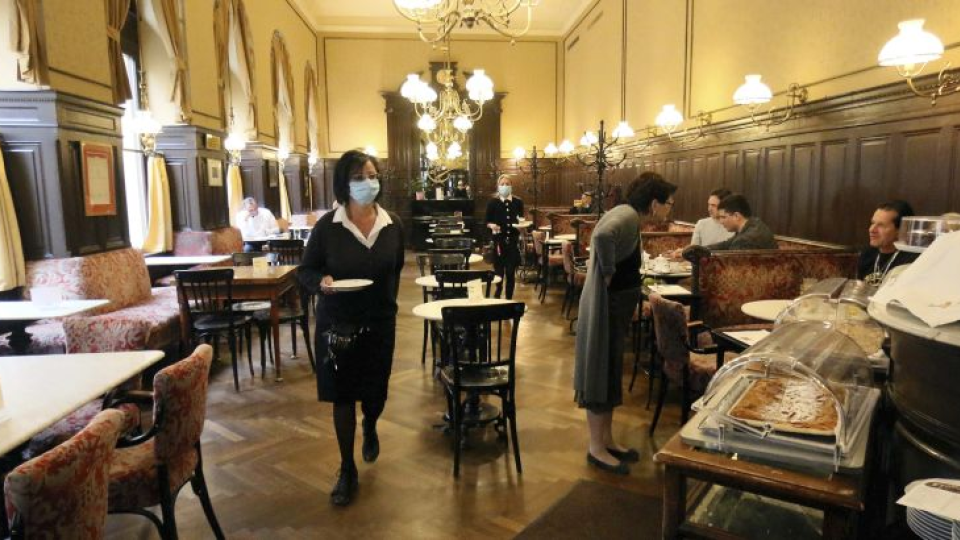 Čašníčka s ochranným rúškom obsluhuje hostí v reštaurácii vo Viedni 15. mája 2020.