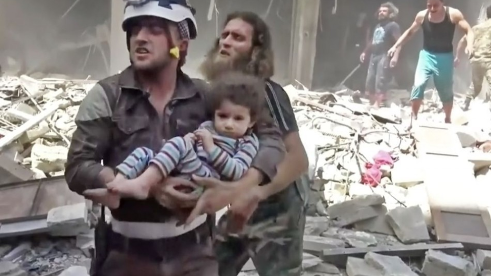 Na snímke miestny člen civilnej obrany  Biele helmy nesie dieťa po náletoch v povstalcami ovládanej časti mesta Aleppo na severe Sýrie v stredu 27. apríla 2016. 
