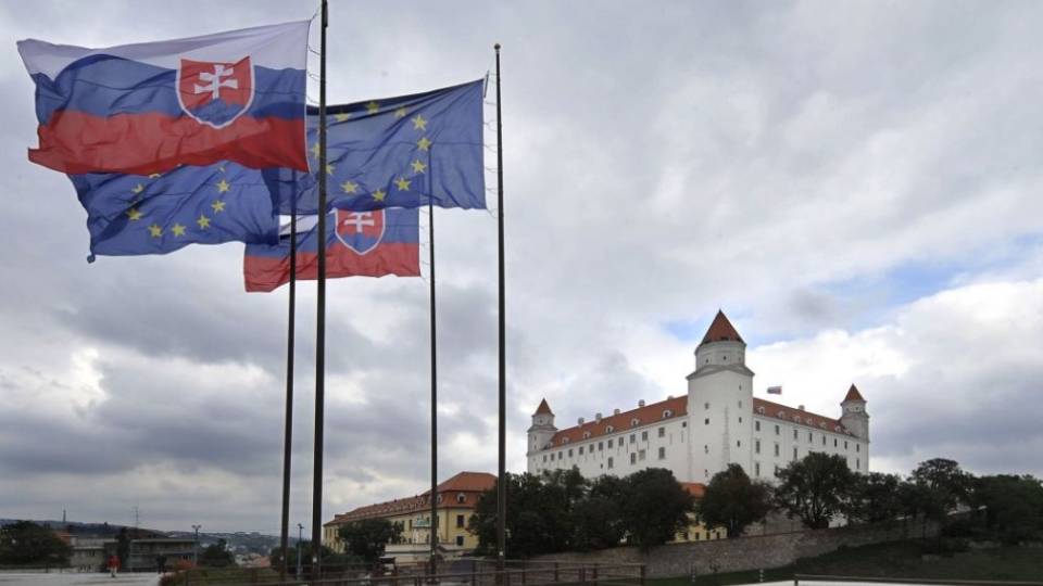 Na ilustračnej foto vlajky SR a EÚ v pozadí s Bratislavským hradom.