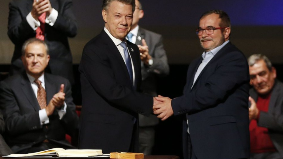 Kolumbijský prezident Juan Manuel Santos (vľavo) si podáva ruku s Rodrigom Londonom (vpravo) známym ako Timochenko, ktorý je lídrom Revolučných ozbrojených síl Kolumbie (FARC). V Bogote podpísali 24. novembra 2016 upravenú verziu mierovej dohody.