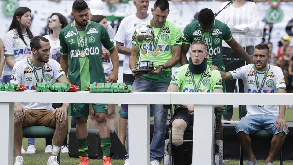 Traja hráči Chapecoense Neto (vľavo) brankár Follmann na invalidnom vozíku a Alan Ruschel (vpravo), ktorí prežili pád lietadla pred takmer dvoma mesiacmi, si prevzali Juhoamerický pohár počas zápasu proti Palmeiras, 21. januára 2017.
