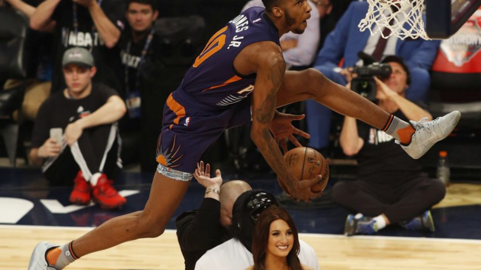 Na snímke hore hráč Phoenixu Derrick Jones Jr. dáva kôš vo výskoku cez tri osoby počas súťaže o najlepšieho smečiara (slam dunk) v rámci podujatia NBA All-Star Saturday Night v New Orleanse v noci na 19. februára 2017.
